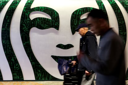 Gente pasando por delante de un establecimiento de Starbucks en Shanghái, China.