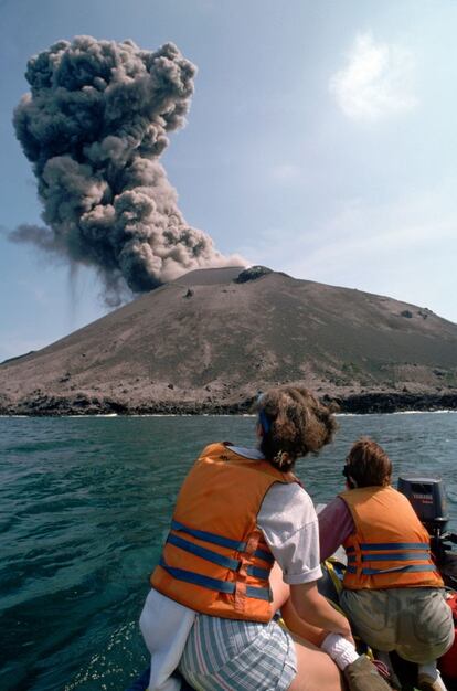 Turistas observando desde un barca una pequeña erupción del volcán Anak Krakatau, en Indonesia.