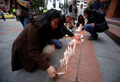 Varias personas encienden velas el d&iacute;a 18 en el centro comercial de Bogot&aacute; atacado la v&iacute;spera. 