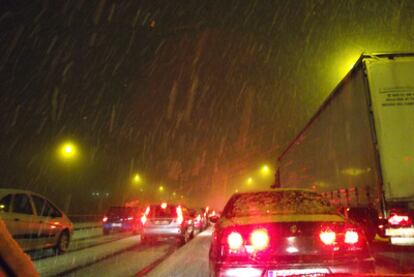 Vehículos parados bajo la nieve durante la noche del viernes en la A-6.