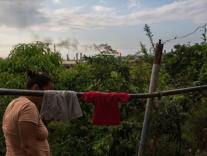 Una vecina cuelga su ropa, cerca de las instalaciones de la refinería Puerto La Cruz de Petróleos de Venezuela, en el Estado de Anzoátegui, en una fotografía de archivo de 2021.