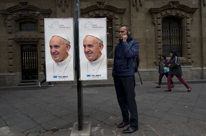 Un hombre en una cabina con fotos del Papa en Ciudad de México.