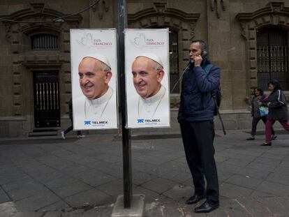 Un hombre en una cabina con fotos del Papa en Ciudad de México.