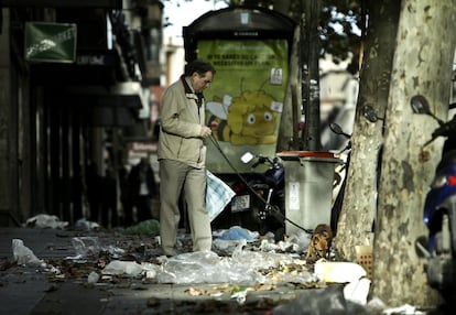 Un hombre pasea a su perro entre la basura tirada en la zona de Atocha, Madrid.