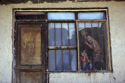 Varios niños sonríen a través de una ventana, en Kabul (Afganistán).