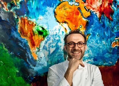 Massimo Bottura (Módena, 1962) en el salón de su restaurante, frente a una pintura de Mario Schifano que representa "el mundo sin fronteras".