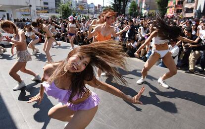 Bailarinas actúan frente a los transeúntes en una plaza frente a la estación de Shinjuku en Tokio.