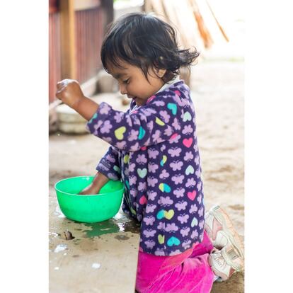 A la hora de lavarse, Sayra juega con el agua, abundante en la localidad en la que vive por la cercanía de un manantial.