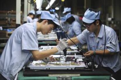 Varios operarios chinos trabajan en una línea de montaje de televisores en una fábrica de Shenyang, en la provincia de Liaoning (China). EFE/Archivo