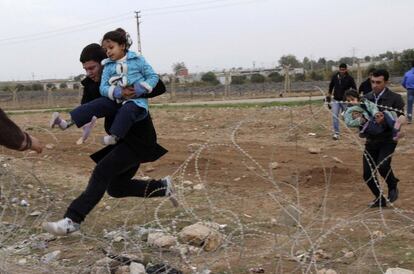 Sirios saltan sobre alambres huyendo de la ciudad siria de Ras al-Ain,ciudad fronteriza turca de Ceylanpinar, provincia de Sanliurfa en noviembre del 2012