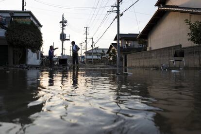 Dos hombres en un área afectada por la inundación el 9 de julio de 2018, en Kurashiki, Okayama, Japón.