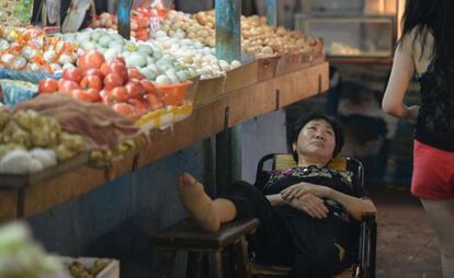 Una vendedora descansa en un mercado de Shanghai