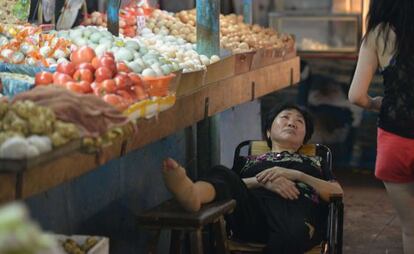 Una vendedora descansa en un mercado de Shanghai