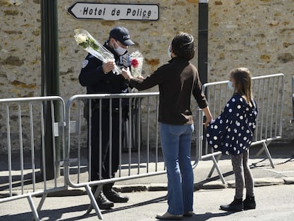 Una mujer entrega un ramo de flores a una policía junto a la comisaría de Rambouillet (cerca de París) donde fue asesinada una agente el pasado viernes.