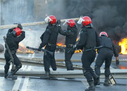 Los trabajadores han colocado barricadas de fuego en la carretera BI-3739 que une la Margen Izquierda con Bilbao y en otro ramal cercano que sale dela zona industrial de Sestao hacia la rotonda que permite enlazar con la autopista A-8. En la imagen, la Ertzaina intenta desbloquear las vas cortadas.