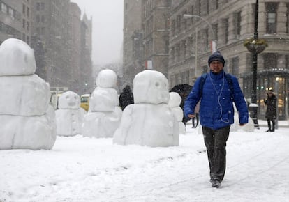 Un transeunte pasa junto a la obra del artista suizo Peter Regli, Reality Hacking No. 320 "Snow Monsters 2015", en Nueva York