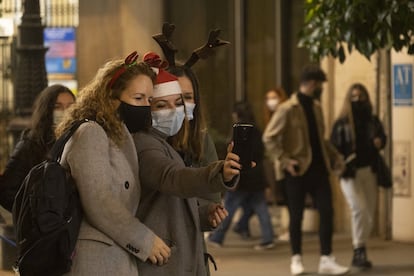 Entre el 18 de diciembre y el 10 de enero, los comercios y resto de establecimientos de Andalucía podrán abrir hasta las 21.00 y los bares podrán abrir con dos turnos, desde la mañana hasta las 18.00 y de 20.00 a 22.30 (hasta la 1.00 en Nochebuena y Nochevieja). El toque de queda se reduce de 23.00 a 6.00 en este periodo, con las excepciones señaladas. En la imagen, tres jóvenes se fotografían en el centro de Sevilla, el viernes.