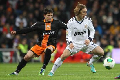 Luka Modric es seguido por el jugador valencianista Piatti.