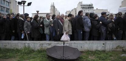 Ciudadanos esperan para recibir comida gratuita, en Atenas.