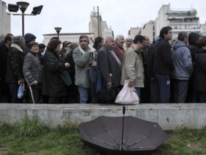 Ciudadanos esperan para recibir comida gratuita, en Atenas.