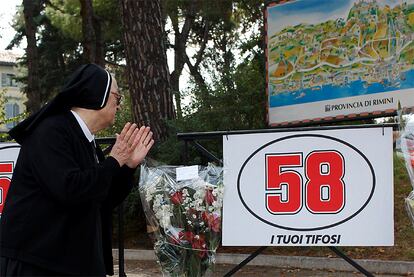 Una monja, seguidora de Marco Simoncelli, deposita unas flores en una esquina de Coriano, cerca de Cattlolica.