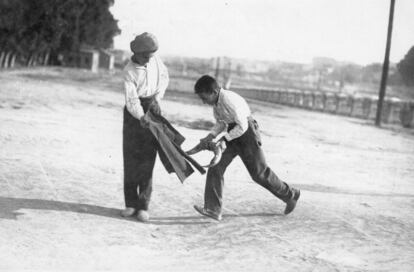 Niños ensayan pases taurinos en un lugar rural de España, alrededor de 1950.