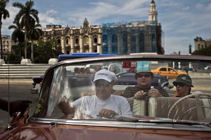 Turistas pasean por La Habana Vieja en un coche clásico americano