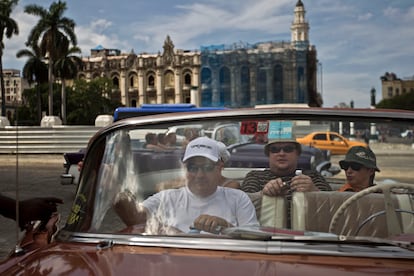 Turistas pasean por La Habana Vieja en un coche clsico americano