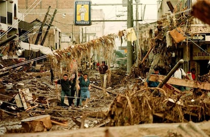 Habitantes de Tegucigalpa (Honduras) se abren paso entre las ruinas de una de las calles de la ciudad, completamente arrasada por Mitch.