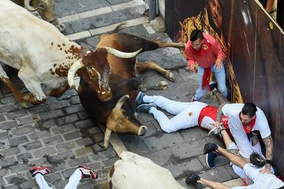 Varios participantes caen durante el quinto encierro de San Fermín, en el que participan os toros de Núñez del Cuvillo. 