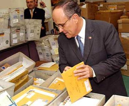 El alcalde de Nueva York, Rudolph Giuliani, abre su correo, en un gesto destinado a disipar temores.