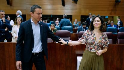 El líder de los socialistas madrileño, Juan Lobato, sostiene este jueves en la Asamblea el brazo de la presidenta, Isabel Díaz Ayuso, después de darle las condolencias por su aborto.