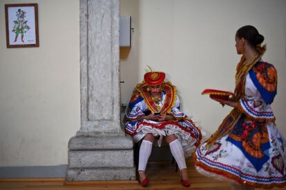 Una joven con el traje tradicional de San Antonio utiliza su teléfono móvil antes del desfile.