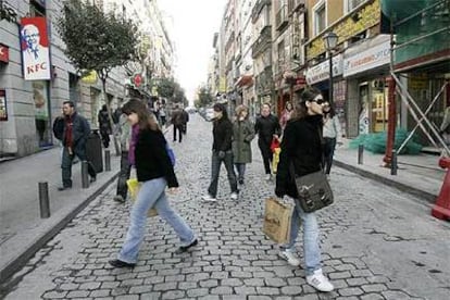Los peatones cruzan despreocupadamente la calle de la Montera, muy cerca de la Puerta del Sol, ante la ausencia de vehículos.