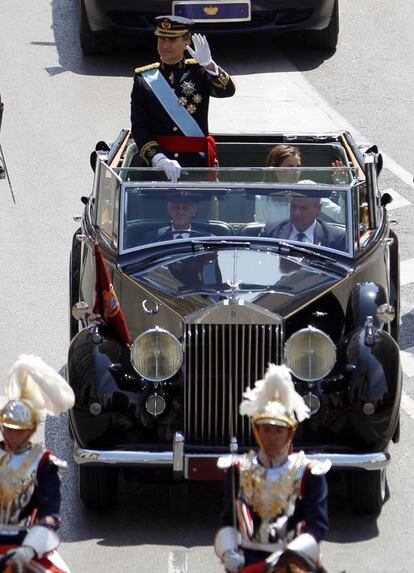 Los Reyes se pasean en coche descubierto por las calles de Madrid.