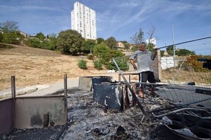 Un hombre entre los restos de su casa en un campamento gitano en Marsella.