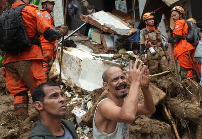 Un hombre pide ayuda para buscar a sus familiares desaparecidos en el deslizamiento de tierra en Morro da Oficina.