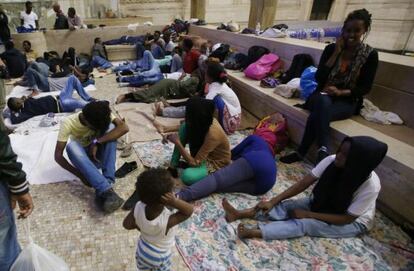 Inmigrantes subsaharianos descansan en la estaci&oacute;n central de Mil&aacute;n.
