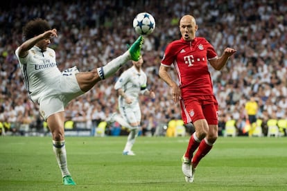 El defensa barsileño del Real Madrid Marcelo (izquierda) golpea el balón ante la mirada de Arjen Robben.