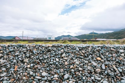 Los guijarros de la playa amontonados contra el muro.