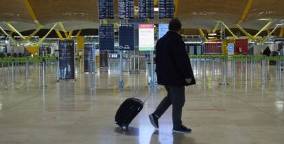 Un pasajero camina por la terminal T4 del aeropuerto de Madrid-Barajas prácticamente vacía.