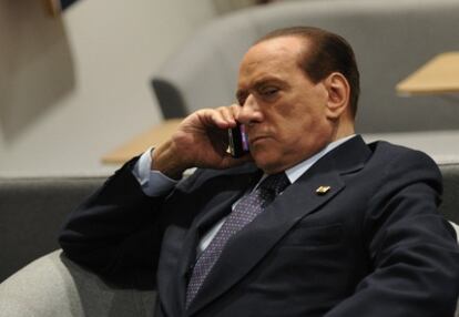 El primer ministro italiano, Silvio Berlusconi, habla por teléfono en un momento de la cumbre.