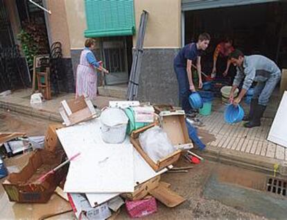 Vecinos de un barrio de Alzira achicaban ayer agua de sus casas.