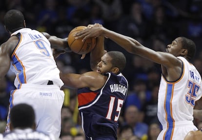 Al Horford, de Atlanta, rodeado por Ibaka y Durant, de Oklahoma.