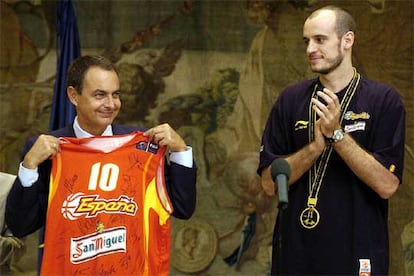 El capitn de la seleccin espa?ola de baloncesto, Carlos Jimnez, aplaude tras entregar su camiseta firmada por todos sus compa?eros al presidente del Gobierno.