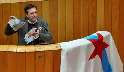 El diputado del BNG, Luís Bará, rompe una imagen del Rey durante su intervención en Parlamento de Galicia, en una imagen facilitada por el BNG.