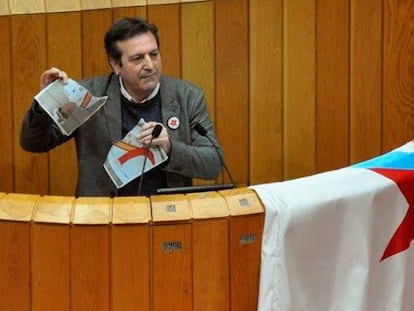 El diputado del BNG, Luís Bará, rompe una imagen del Rey durante su intervención en Parlamento de Galicia, en una imagen facilitada por el BNG.