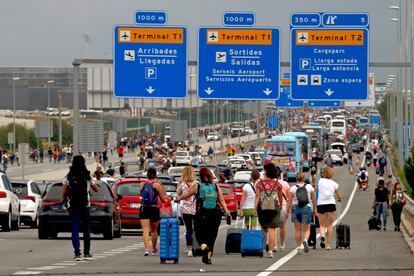 Imagen de octubre de 2019, durante las protestas en el aeropuerto de El Prat organizadas por Tsunami Democràtic. Viajeros afectados por el colapso del aeropuerto caminaban por la carretera de acceso con sus maletas
