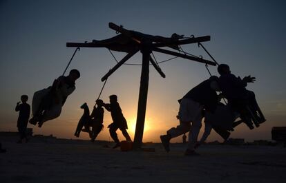 Jvenes afganos juegan al atardecer en un columpio a las afueras de Mazar-i-Sharif (Afganistn).