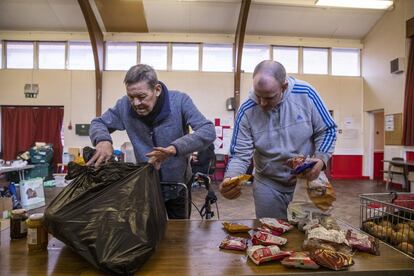A la derecha de la imagen, Chris, de 40 años, ayuda como voluntario a Collin, de 61, en el banco de alimentos de Newcastle.